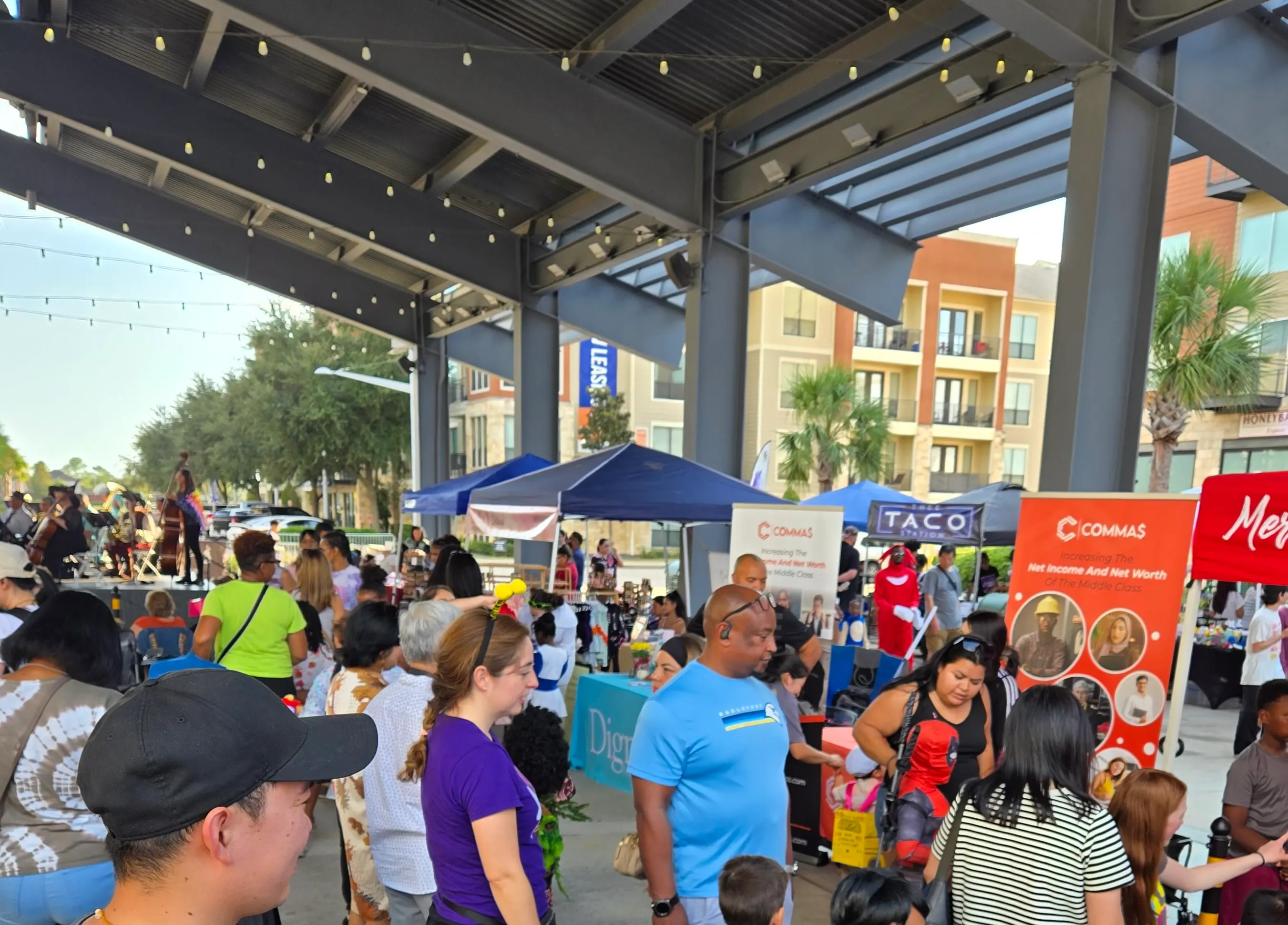 Festival visitors meeting community vendors under the pavilion